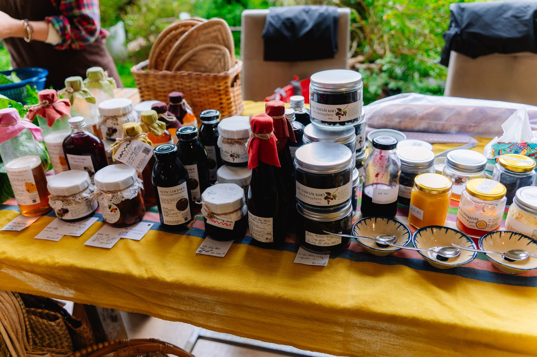 Jars of preserves and honey on a wooden table at a farmers market stall