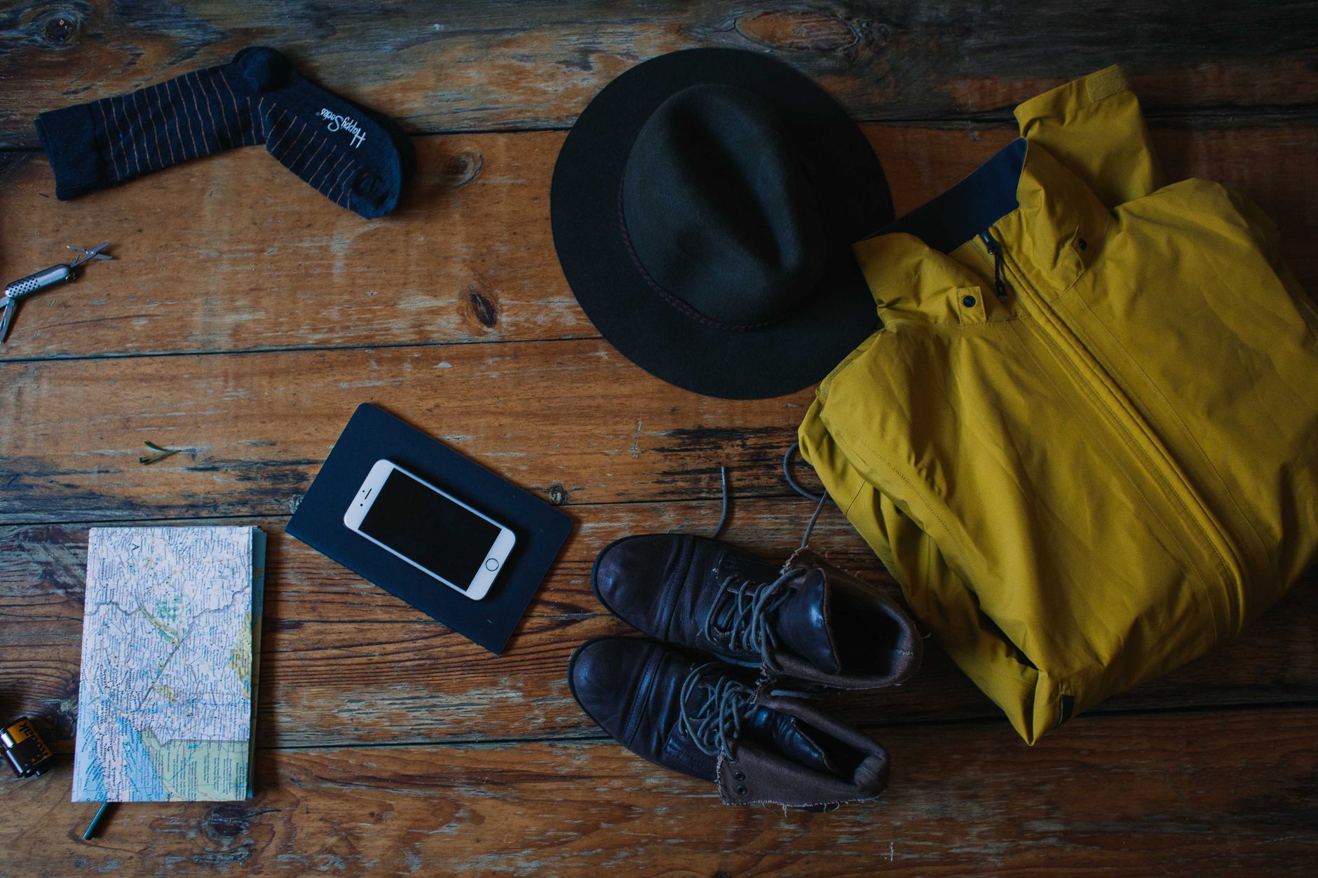 The contents of a day hiking pack laid out on a wooden table